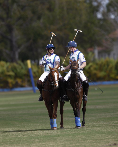 Two men engage in a game of polo on horseback.